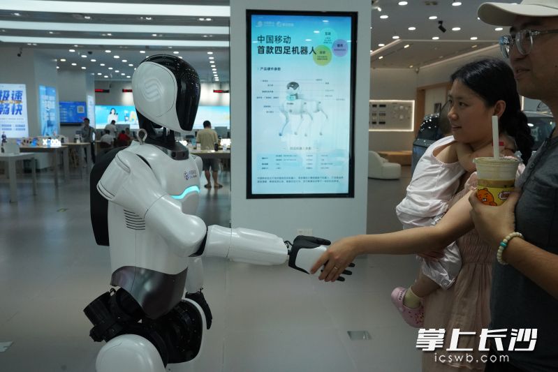 “灵犀”机器人与客户互动握手。 均为长沙移动供图