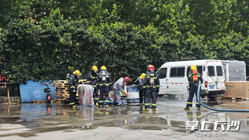 消防员和专业人员对泄漏油桶进行打包转运。