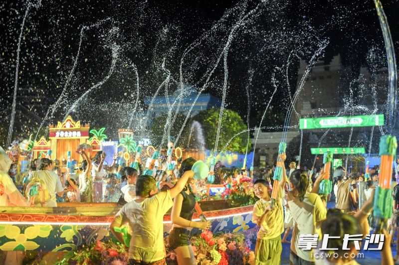 大人小孩手持水盆、水枪，向着身边的人扬起水花。