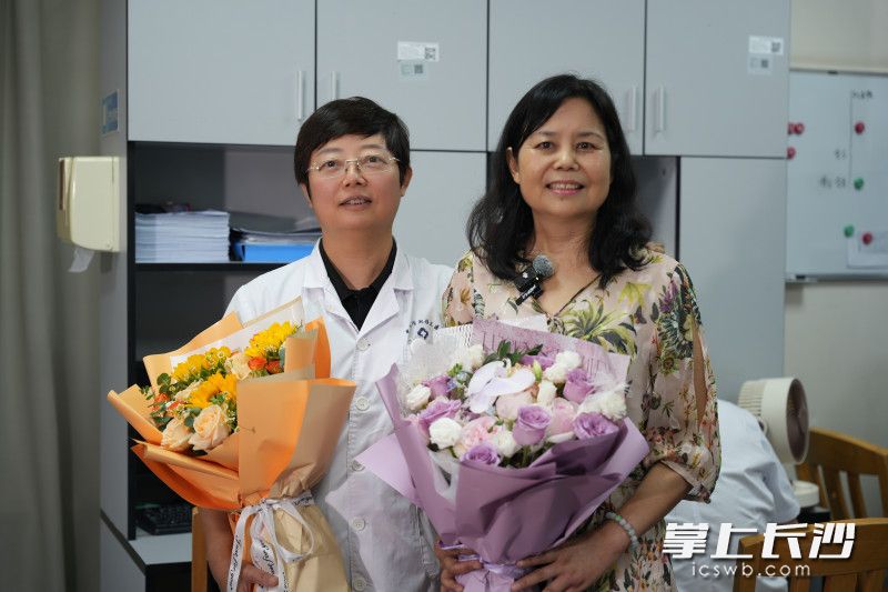 尹女士（右）与中南大学湘雅三医院血液内科蒋铁斌教授互赠鲜花并留影。 均为长沙晚报全媒体记者林暘摄