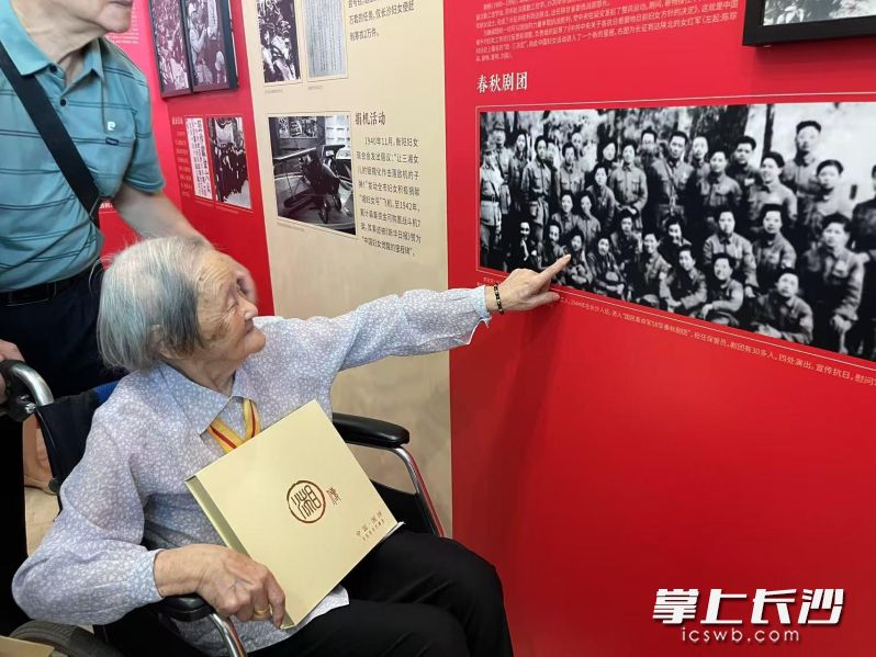 百岁抗战女兵李淑芳在春秋剧团演出合影前向参观者介绍年轻时的自己。 均为通讯员供图