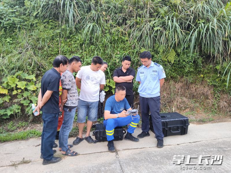 岳麓蓝天救援队队长谭章（坐着的）用无人机搜救女童。 均为通讯员供图