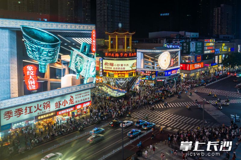当夜幕降临，黄兴路的裸眼3D大屏依旧明亮，青铜器国宝的光影在车流人潮中格外醒目。