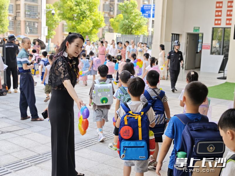 1日上午，校长许薇（前中）在学校门口迎接同学们返校。均为长沙晚报通讯员 欧文彬 供图