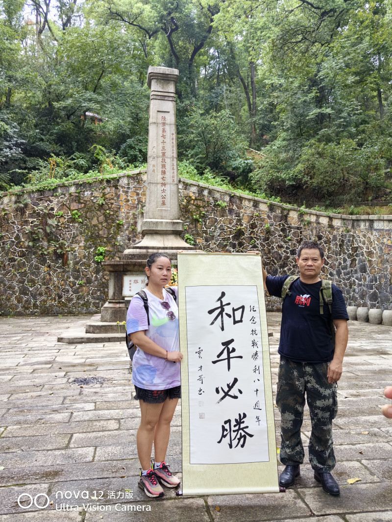 志愿者举起“和平必胜”的书法作品，深切缅怀抗日英烈。  长沙晚报全媒体记者 袁云才 摄