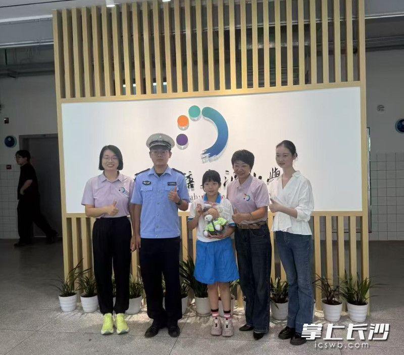 雨花交警和失主谭女士到学校感谢拾金不昧的李艺萌。受访者供图