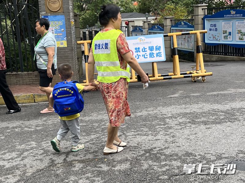 雷锋志愿者牵着小朋友上下学。