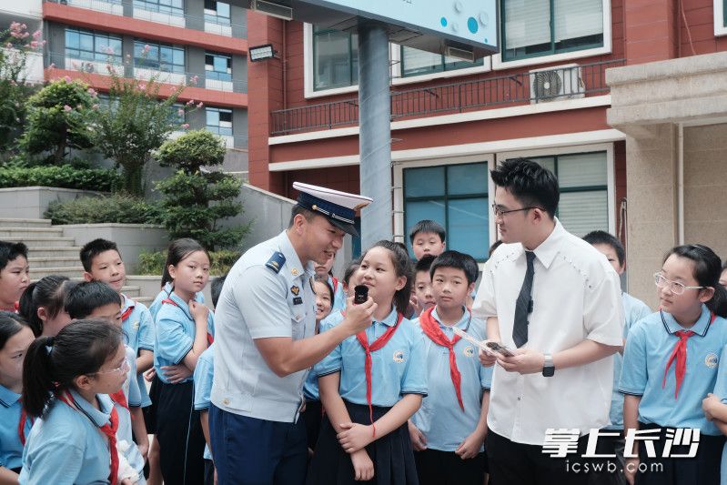 消防员与学生进行消防知识互动。