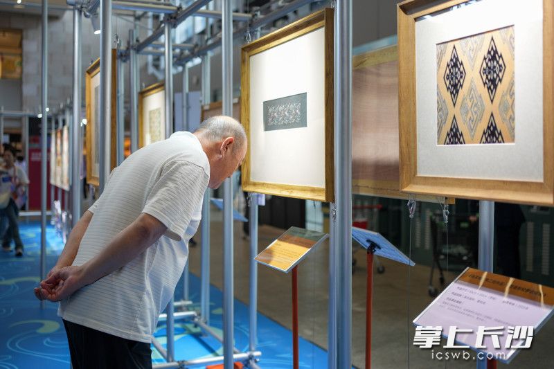 老爹爹在展区领略传统工艺与现代设计精彩碰撞的魅力。