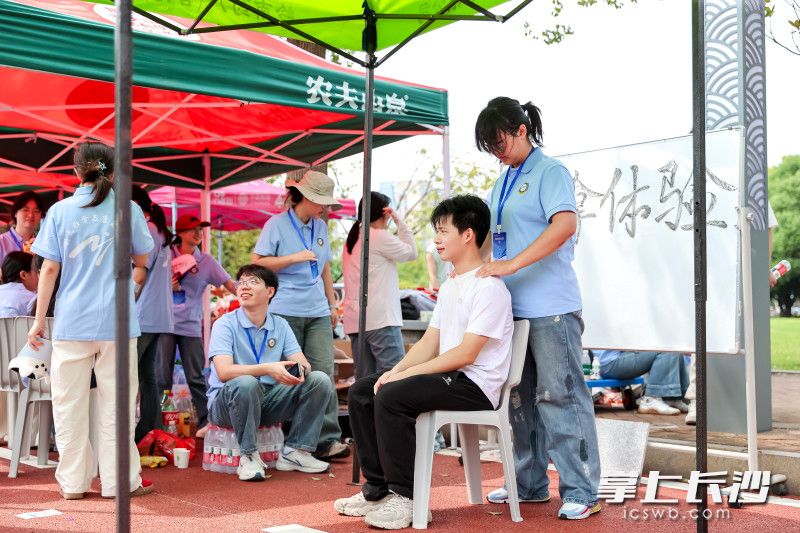 湖南中医药大学新生报到点，一名同学正在体验推拿。
