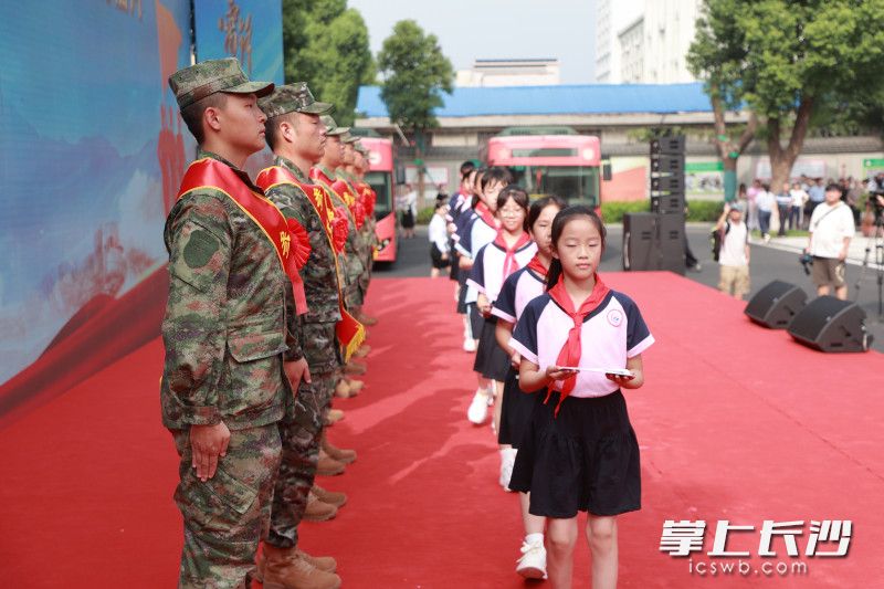 “雷小锋”代表将贴有“雷锋”英模邮票的明信片庄重赠送给新兵代表。