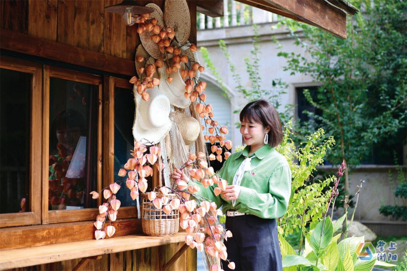 山水边美学庭院餐厅里,设计师陈果苹正在为院子更换装饰品。彭红霞摄 山水边美学庭院餐厅里,设计师陈果苹正在为院子更换装饰品。彭红霞摄