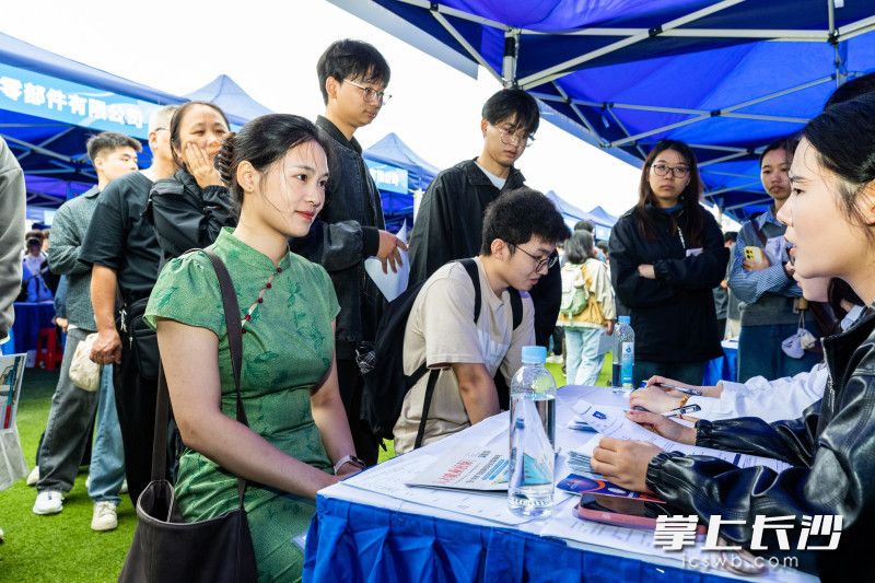 一求职者穿旗袍在湖南中勘北斗研究院有限公司展位应聘。