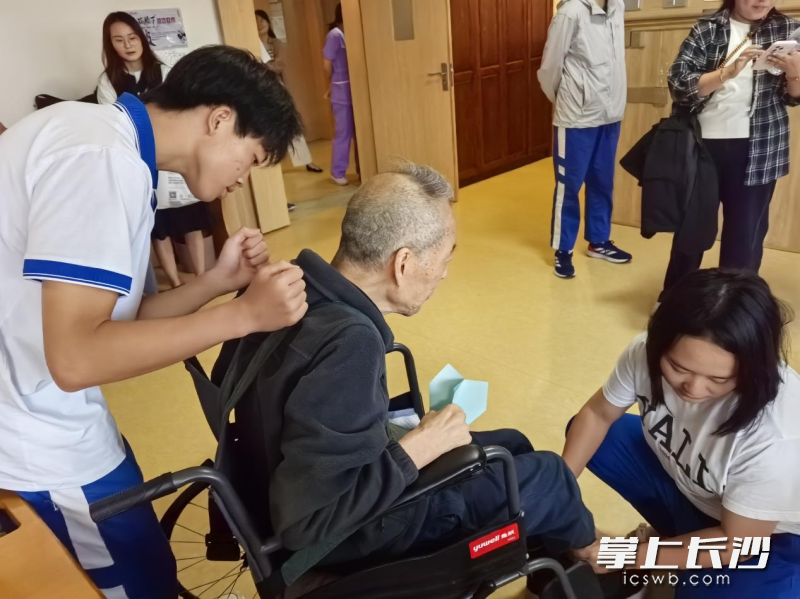 在养老服务中心，雅礼学生们为老人捶背、按摩。
