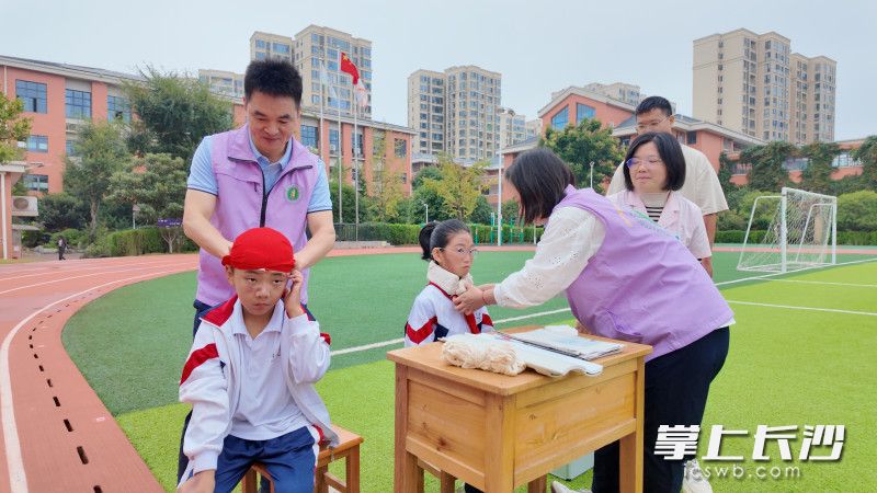 急救人员对“受伤”学生进行急救包扎。