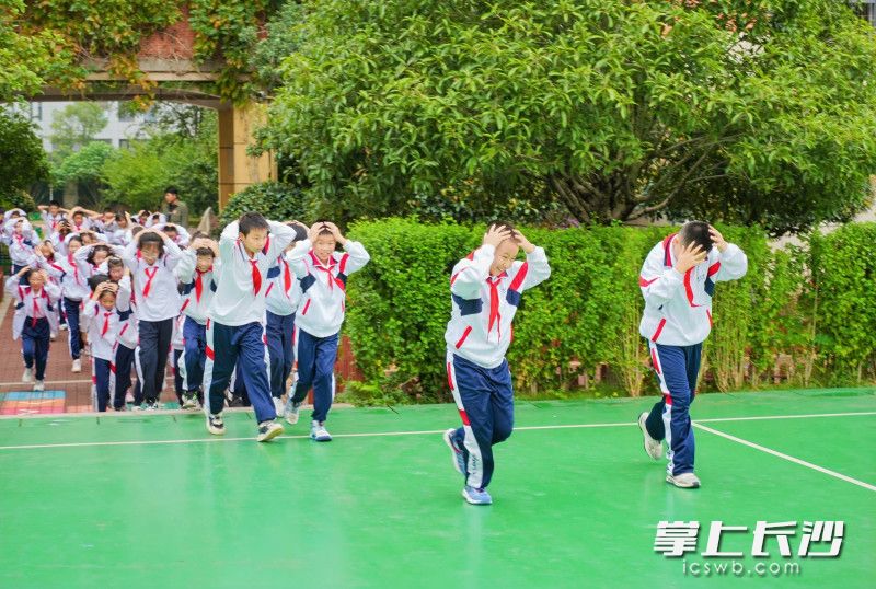 地震应急疏散演练中，该校五年级师生有序迅速撤离至操场。
