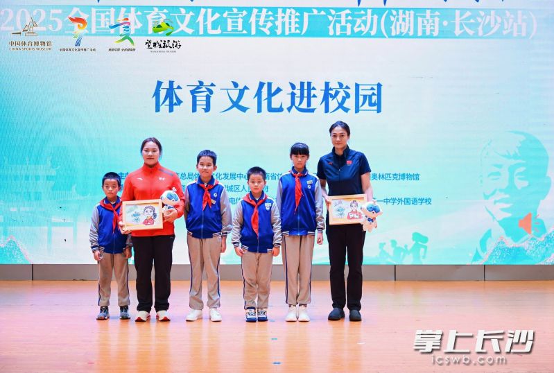 “雷小锋”向两位奥运冠军赠送学校的文创产品。