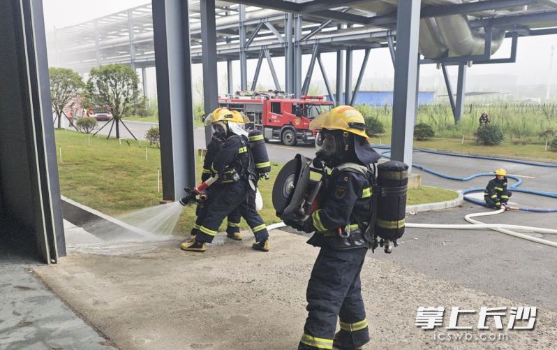 消防员利用水枪掩护破门进行内攻搜救。 均由长沙晚报通讯员唐鑫摄