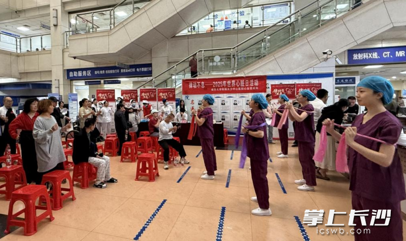 医护人员带领社区居民及病友，共同学习易于掌握的“心脏康复弹力带操”。