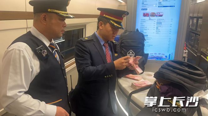 广铁集团长沙客运段工作人员清点朱先生背包内的财务。  长沙晚报通讯员 殷庆 供图