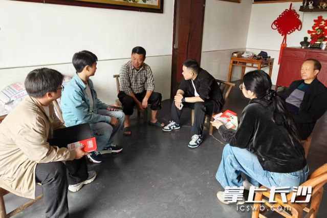 一份份图文并茂的《平安靖港你我共建》宣传折页逐户送到村民手中。  均为长沙晚报通讯员赵言供图
