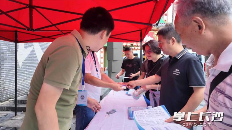 在宣传点，市民游客正积极参与答题活动。