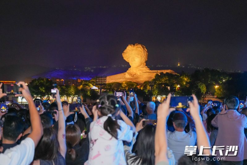 夜晚的湘江两岸灯光璀璨，游船经过橘子洲头，游客们纷纷拿起手机拍照。 均为长沙晚报全媒体记者邹麟摄