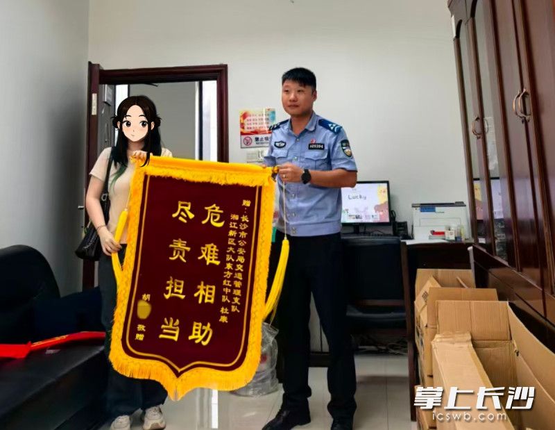 胡女士向杜康送上锦旗。 湘江新区交警供图 胡女士向杜康送上锦旗。 湘江新区交警供图