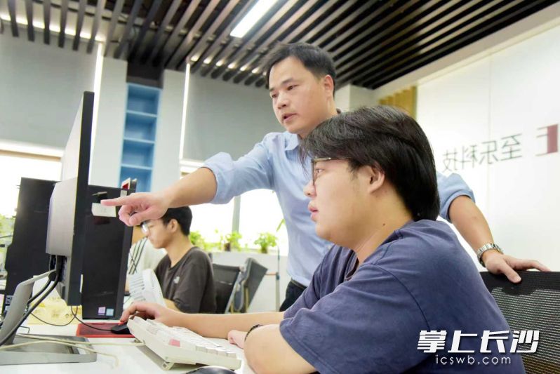 蒋宇（左一）与同事一起研究工作。长沙晚报通讯员 朱莉摄