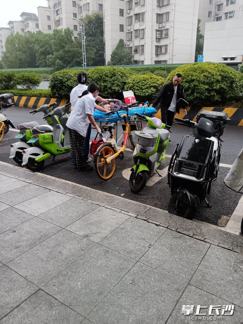 众人合力将老人送医。