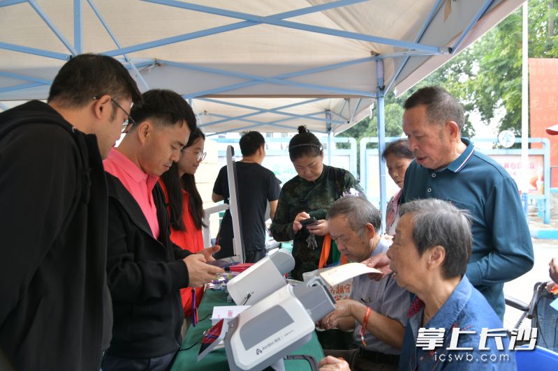 “忆路相守 你我相伴”长沙市老年人认知障碍照护关爱活动现场，志愿者正在为老年人进行各类监测。