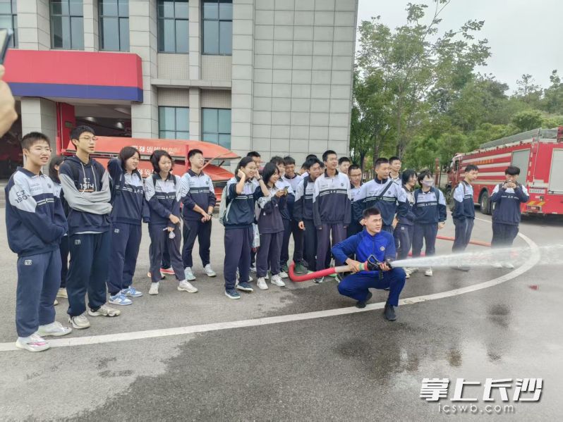 消防员演示水带喷射。