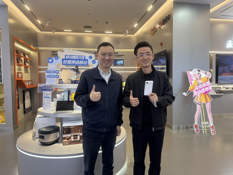 东塘营业厅首位现场购机的客户李先生（右）手持iPhone Air与移动终端公司湖南分公司副总经理徐星合影。