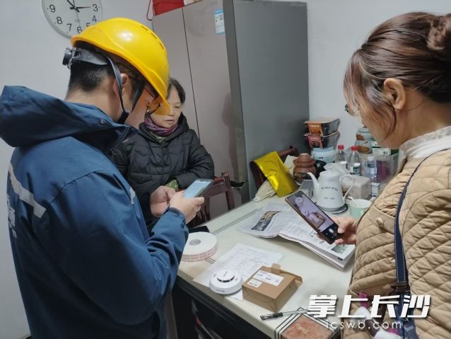 工作人员上门安装烟感报警器。 长沙晚报通讯员 孙岩岩供图 工作人员上门安装烟感报警器。 长沙晚报通讯员 孙岩岩供图