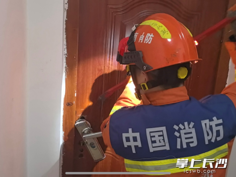 消防员正在破门营救。 长沙晚报通讯员 罗霜操 摄