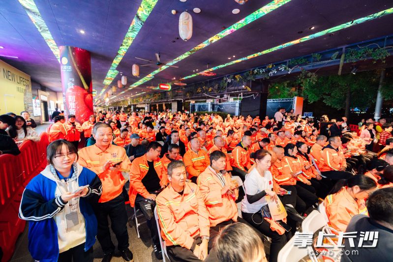 环卫工人既是演员也是观众，在精彩演出中享受节日的快乐。