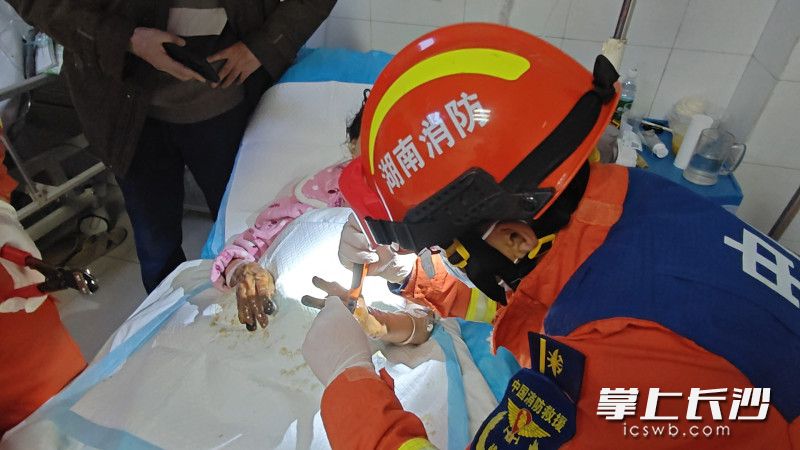 消防员正帮助女子取下戒指。长沙晚报通讯员 王磊 摄