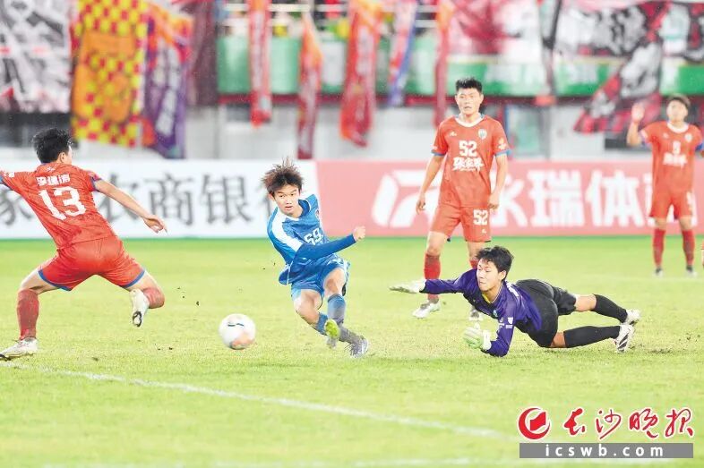 10月19日，长沙队年纪最小的队员、16岁的马子宜（蓝）在对阵张家界队比赛中射门。王志伟 摄