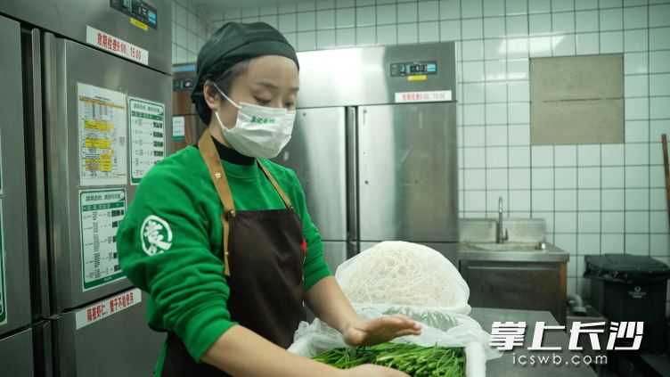 唐雅静在准备食材，如今她已经能轻松应对门店的事务。