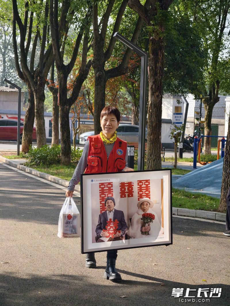 长沙市摄影家协会秘书长余佳桂给老人家送来婚纱照。