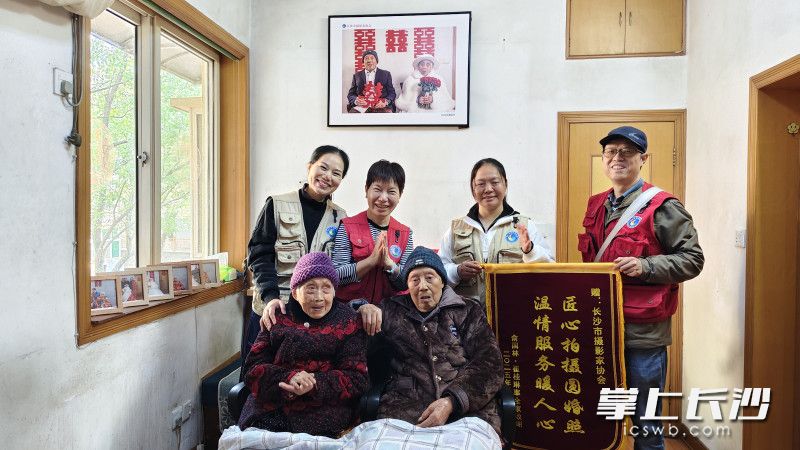 长沙市摄影家协会的摄影师与两位老人合影。