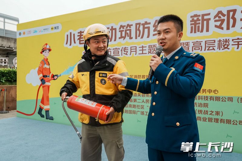 骑手小哥现场学习使用灭火器。 骑手小哥现场学习使用灭火器。
