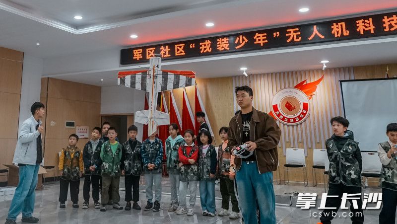 指导老师在狭小的室内表演固定翼无人机飞行。