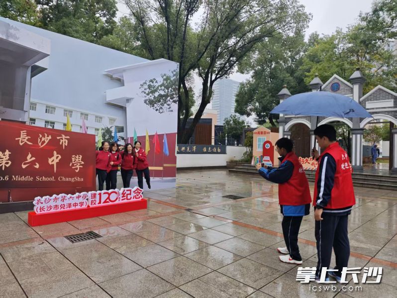 校园“红马甲”小志愿者热情为回校的学长打卡拍照。 校园“红马甲”小志愿者热情为回校的学长打卡拍照。