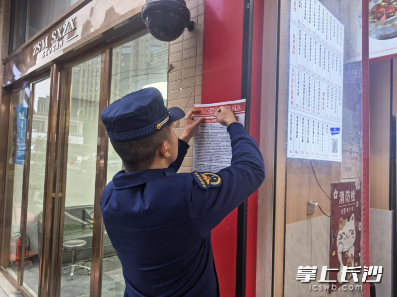 宣传服务队在张贴提示海报。长沙晚报通讯员 方圆 摄