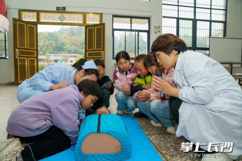 医疗志愿者向孩子们演示心肺复苏操作步骤