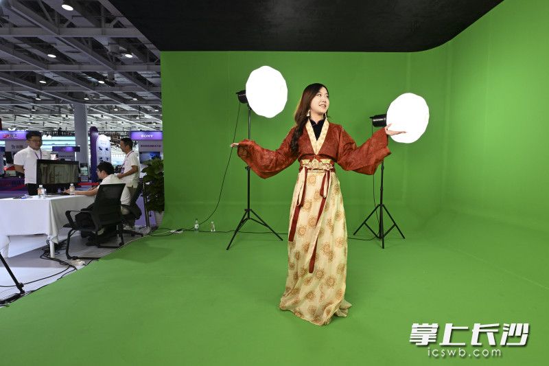 一位观众身着汉服在体验虚拟场景的拍摄。