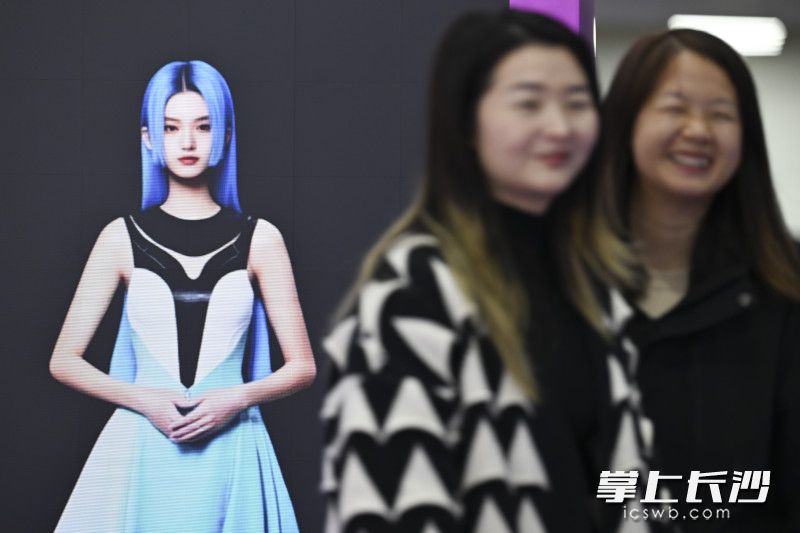 被AI数字人逗笑的两个观众。