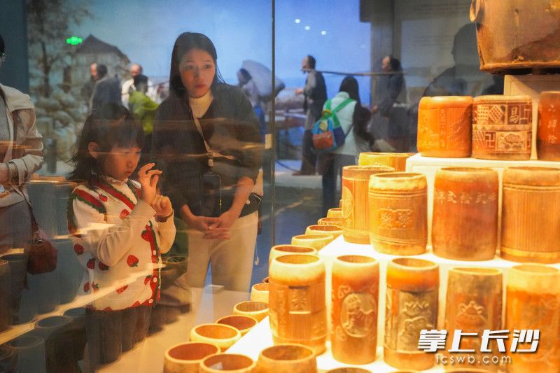 隆平水稻博物馆内,一位小女孩一边观看着展品,一边临摹着展品上的汉字。 隆平水稻博物馆内,一位小女孩一边观看着展品,一边临摹着展品上的汉字。