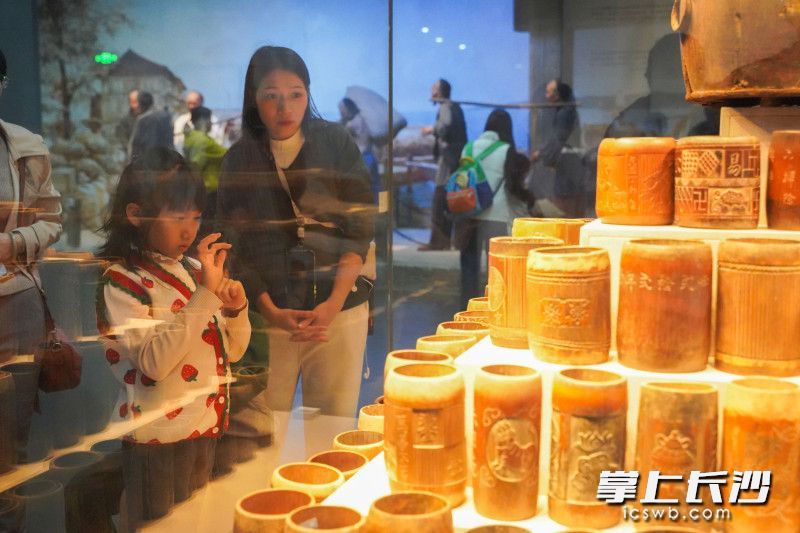 隆平水稻博物馆内,一位小女孩一边观看着展品,一边临摹着展品上的汉字。 隆平水稻博物馆内,一位小女孩一边观看着展品,一边临摹着展品上的汉字。